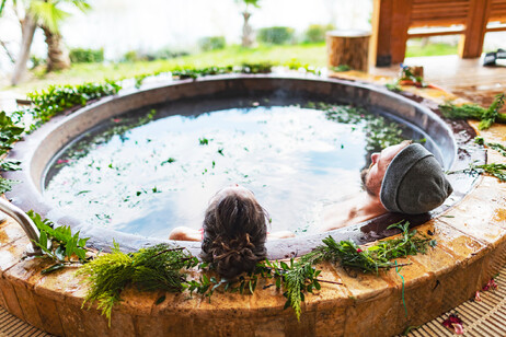 Una coppia si rilassa con un bagno caldo termale all'aperto foto iStock.